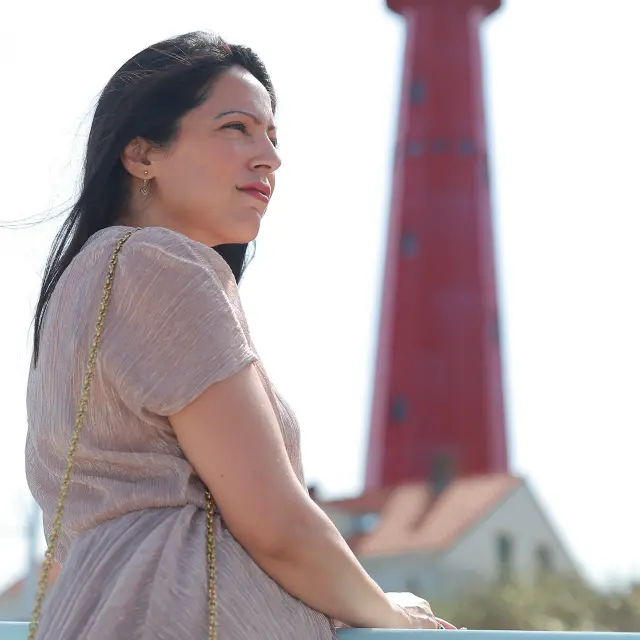 Ashmita Krishna Sharma met op de achtergrond een rode vuurtoren.