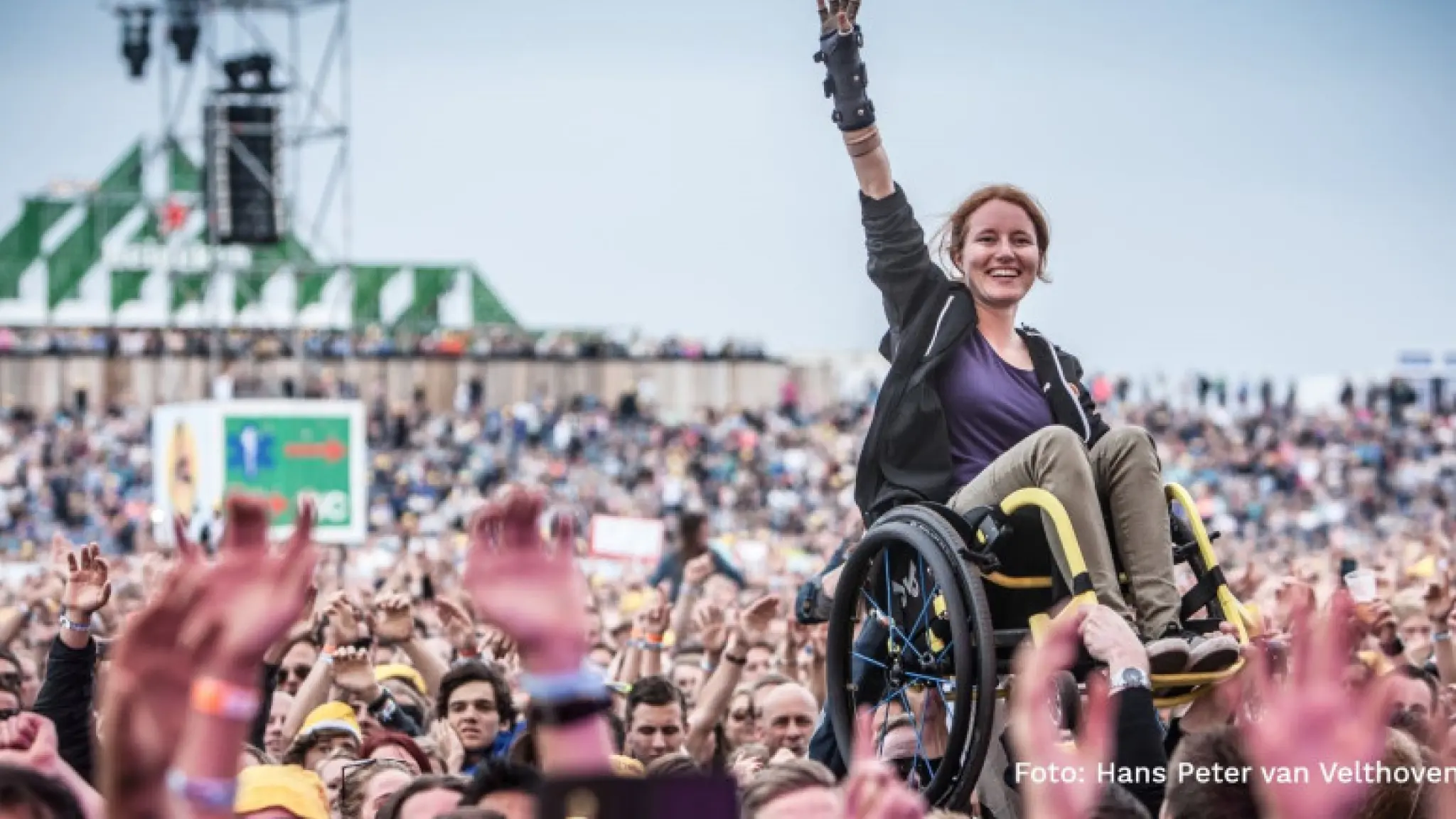 vrouw in een rolstoel crowd surfing op een festival