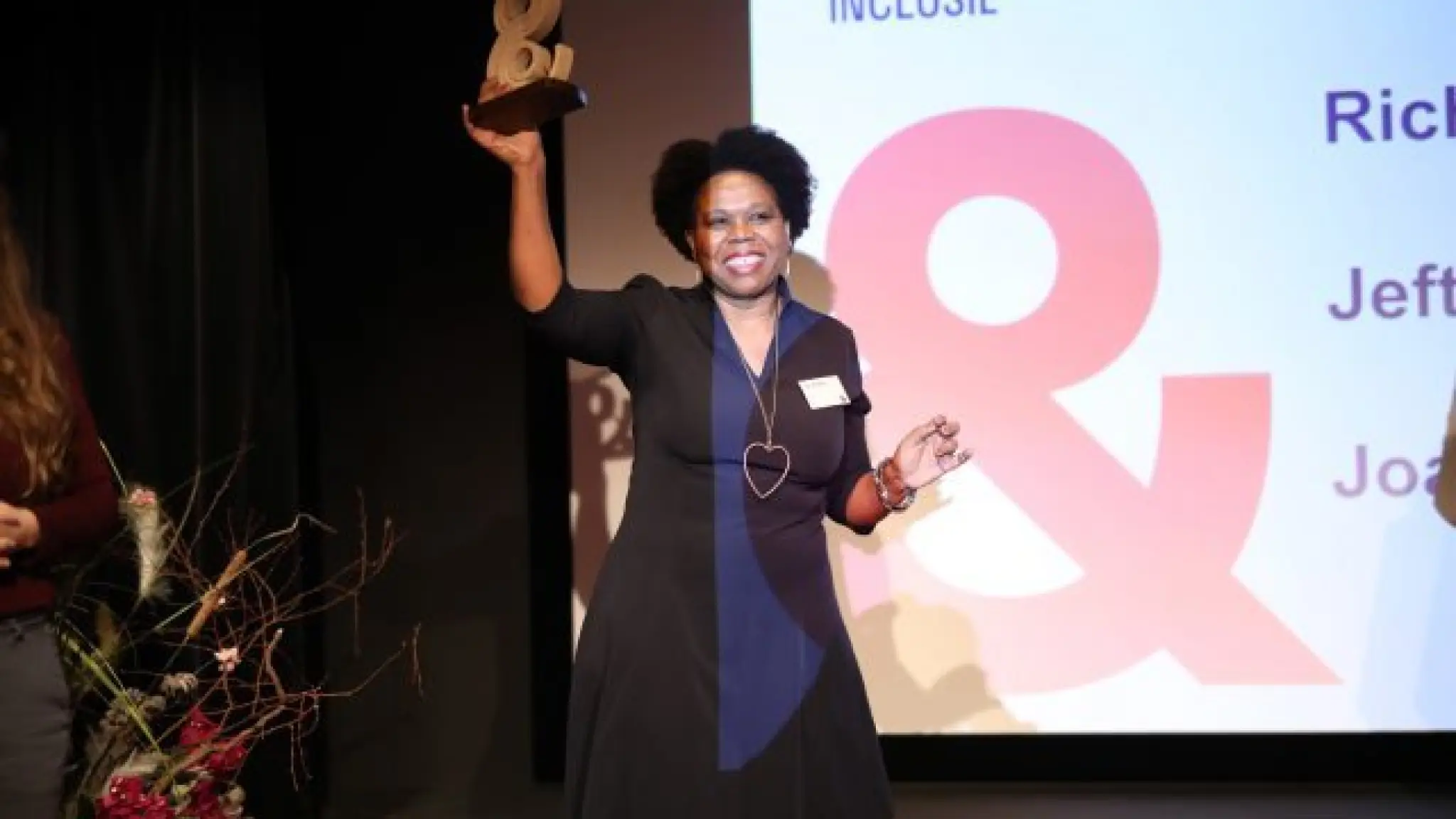Joan Windzak houdt haar gewonnen award omhoog