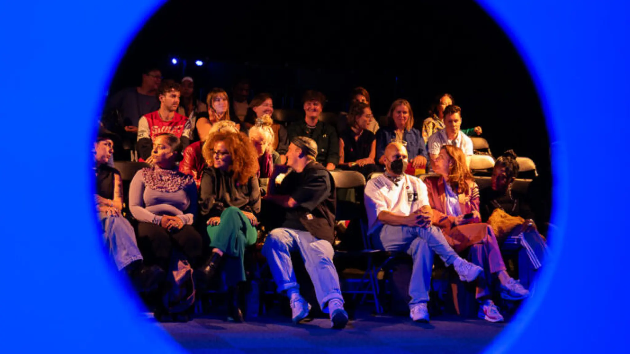 Rond uitgesneden foto van publiek tijdens de uitreiking van de &Awards, met een blauw kader eromheen