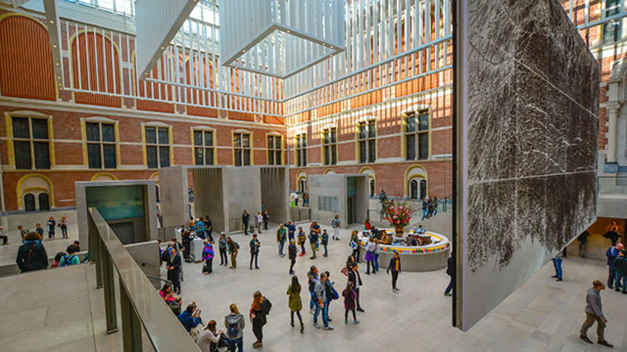 een ruimte van het rijksmuseum met bezoekers die kunstobjecten aan het bezichtigen zijn