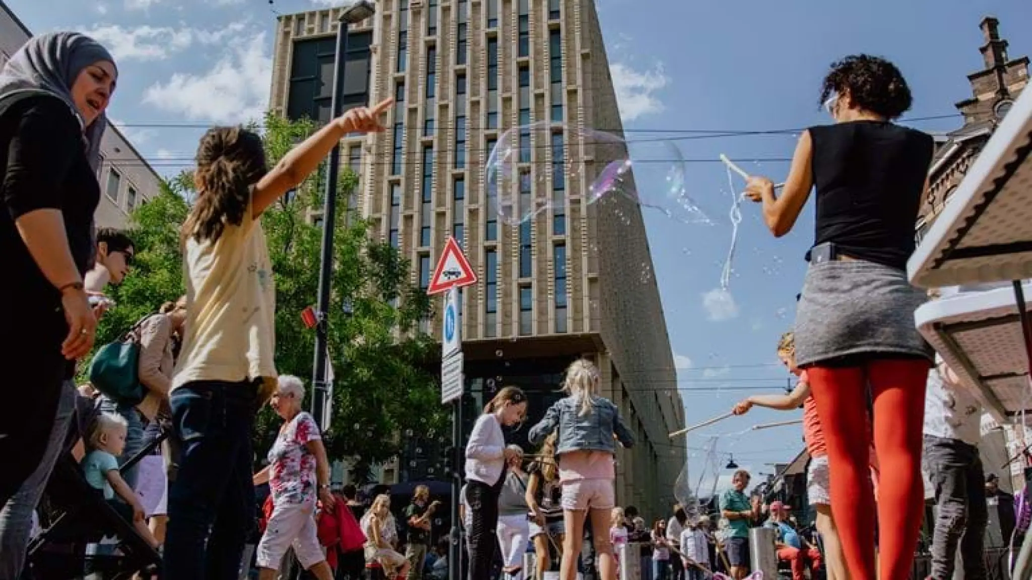 Diverse groep mensen staan voor het gebouw van Rozet