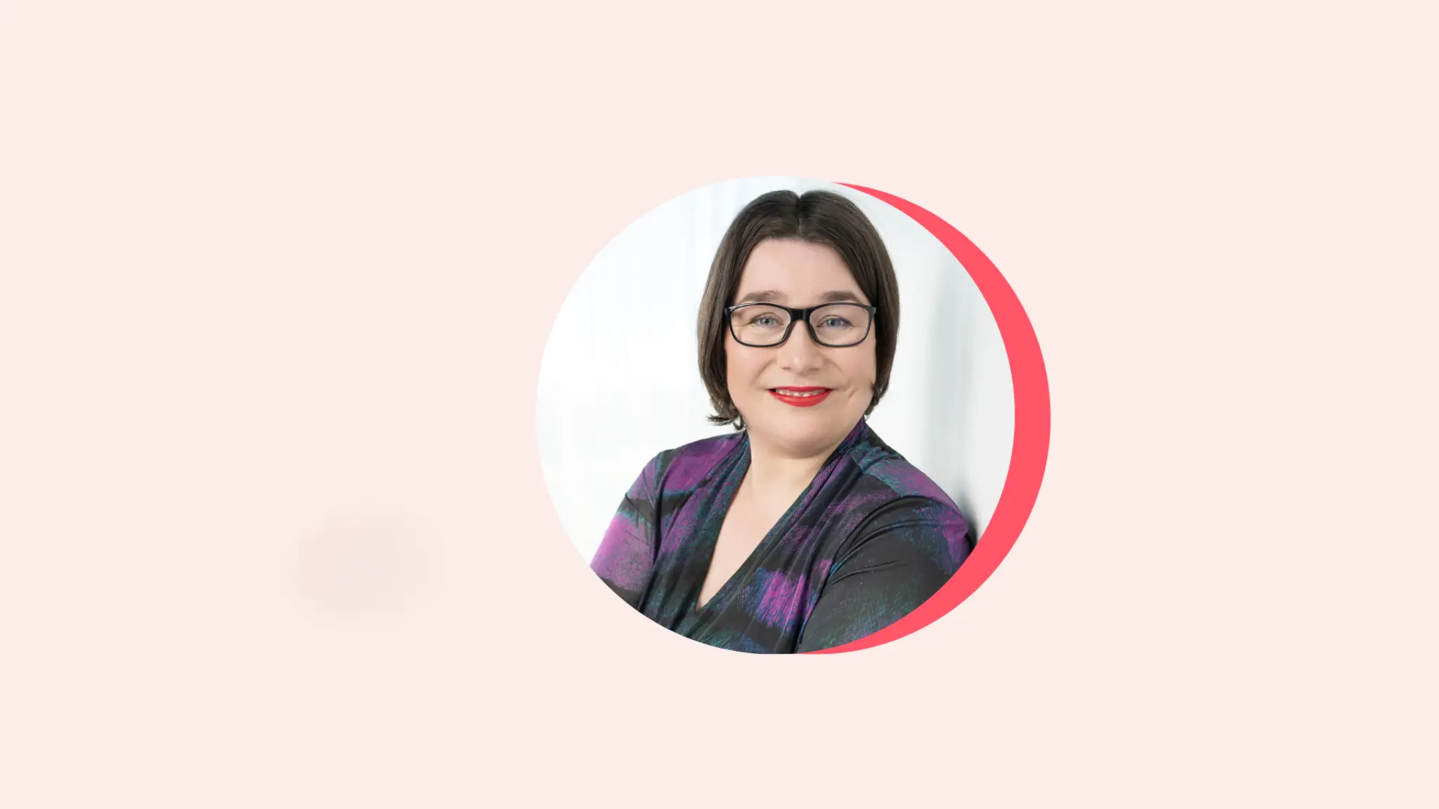Ronde uitsnede van een foto van Marianne Dijkshoorn in een lichtroze vlak. Ze draagt een paars-zwarte jurk, een donkere bril en rode lippenstift. Ze kijkt vriendelijk glimlachend naar de camera. Rechts langs de foto zit een donkerroze rand.