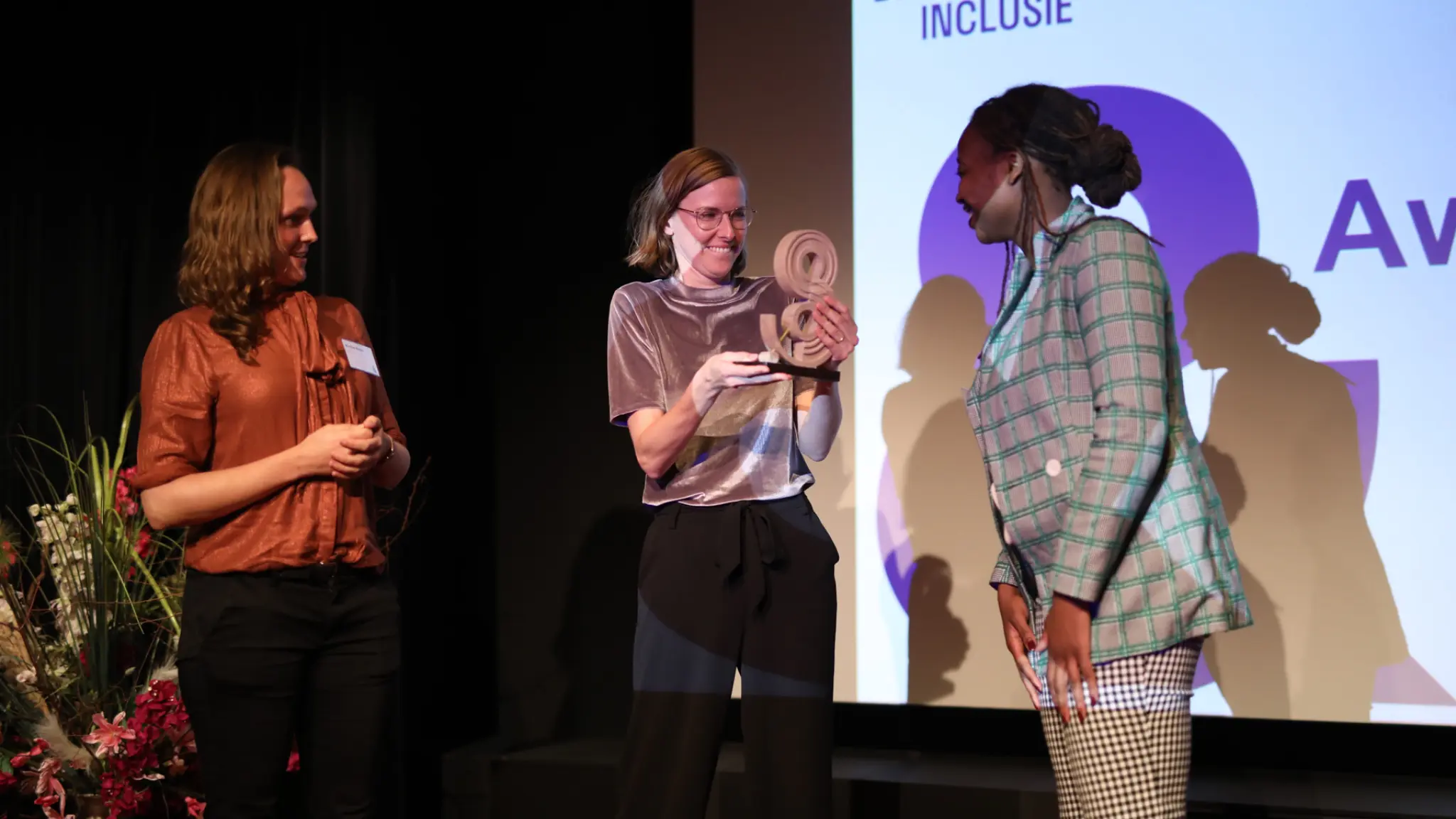 Roos Wattel van de organisatie Wat Telt neemt de &-award in ontvangst